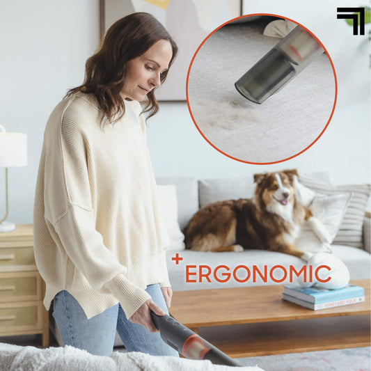 Person using Lightweight Handheld Vacuum With Crevice Tool & Storage Dock in a room with a dog showing ergonomic feature 